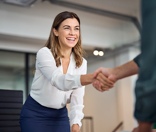 Smiling attorney extending her hand for a handshake with a representative from a law firm SEO agency.