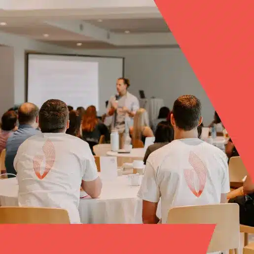People sitting at tables listening to a conference