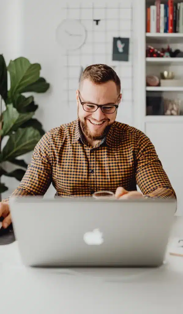 Man smiling while using laptop