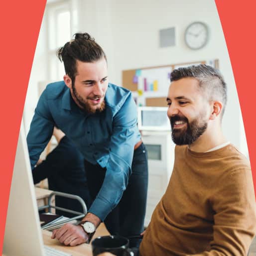 A couple of men chatting and collaborating while using a computer