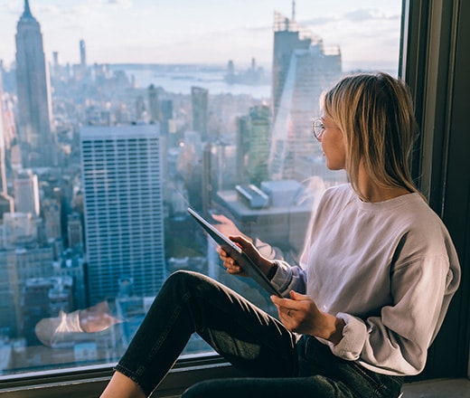 An SEO agency employee works on strategic planning while looking at the New York City skyline.