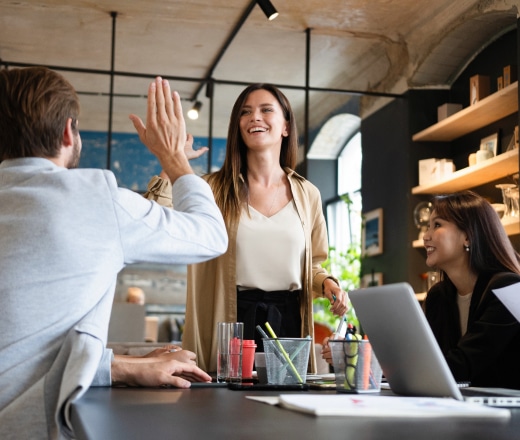 Smiling colleagues in a modern office may be celebrating or reviewing something tied to search engine optimization services.