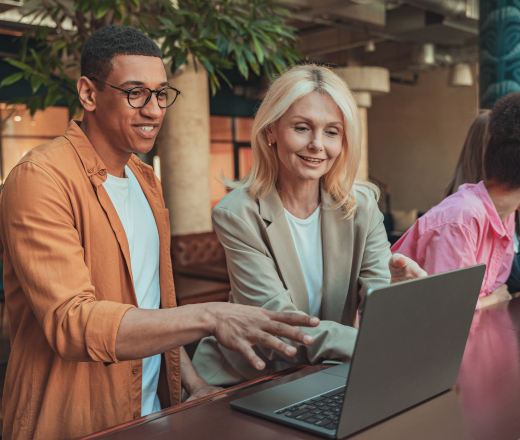 Two professionals smiling while collaborating on off-page SEO services in a modern indoor setting.