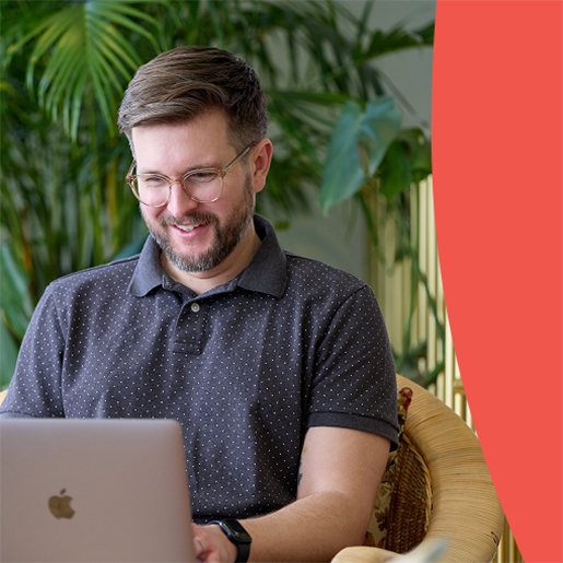 Man works on a laptop in a relaxed setting, maybe reviewing AEO marketing results or drafting digital content.