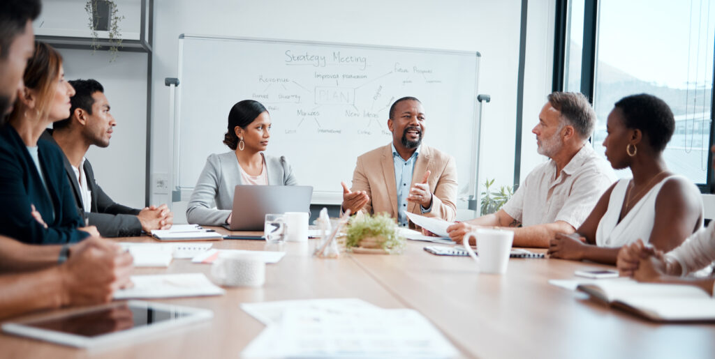 A group of office workers discusses the strategy for their upcoming enterprise SEO site migration.