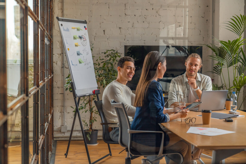 A group of professionals in an office discusses how to work with a technical SEO agency.